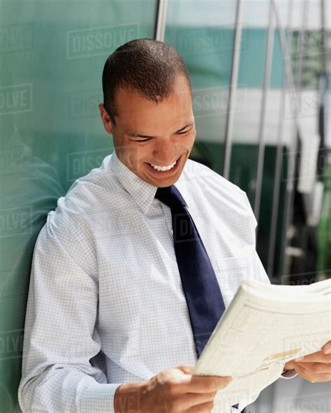Smiling Businessman Reading A Newspaper Stock Photo Dissolve
