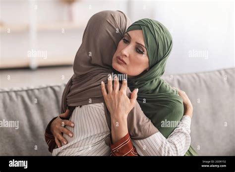 Senior Muslim Mother Hugging Unhappy Adult Daughter Wearing Hijab