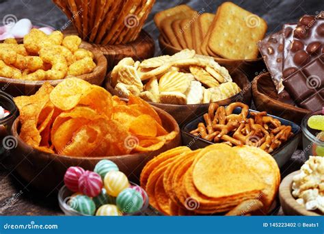 Salty Snacks Pretzels Chips Crackers In Wooden Bowls On Table Stock