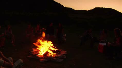 group sits around campfire at dusk stock footage sbv 300150594