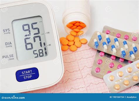 Automatic Blood Pressure Meter And Pills On Cardiogram Graph Background