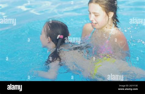 Beautiful Young Girl Teaches Her Little Sister To Swim In The Pool Stock Video Footage Alamy