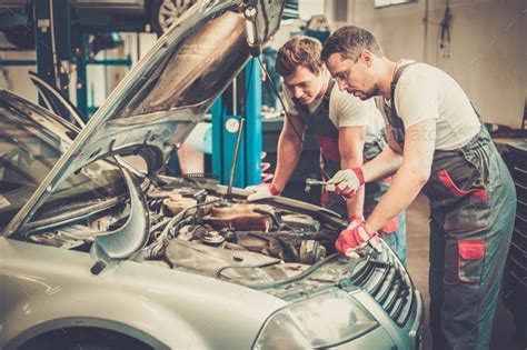 Two Mechanics Fixing Car In A Workshop Stock Photo By Nejron Photodune