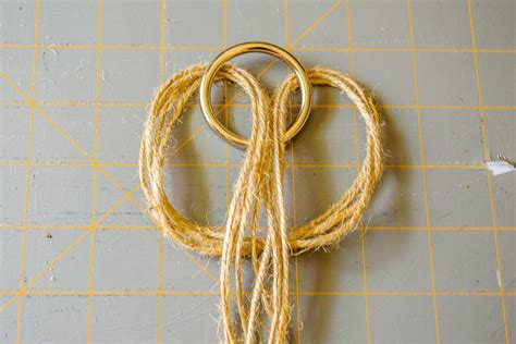 Using your 5 foot long piece of string, tie a loop knot right below the ring. How to Make a Macrame Plant Hanger | HGTV