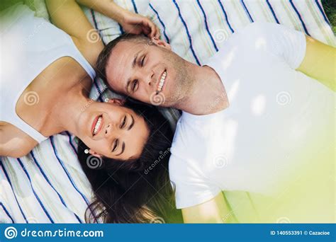 Horizontal Top View Of A Smiling Couple In Love Lying On A Picnic Blanket Stock Image Image
