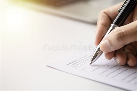 Image Of Hand Using Writing Pen With Questionnaire Or Paperwork Survey