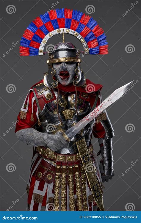 Fearful Roman Soldier With Gladius Posing Against Gray Background Stock