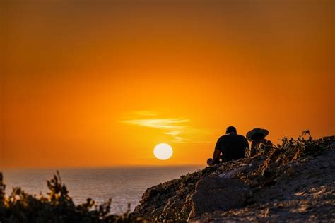 Casal Jovem Assistindo O P R Do Sol Na Praia De Barbate Ao Lado Do Farol Trafalgar Cadiz Foto