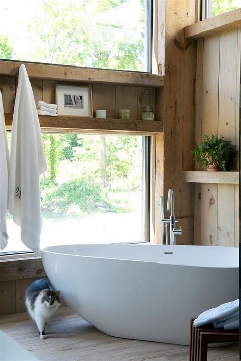 Two Story Rustic Cabin Bathroom Features An Oval Freestanding Bathtub