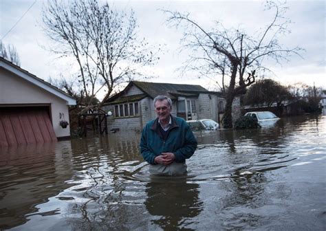 A Resident Leaves His Flood Affected Home Adjacent To The River Thames