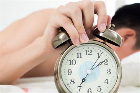 Alarm Clock With Man Waking Up On Bed In Background Stock Photo Image