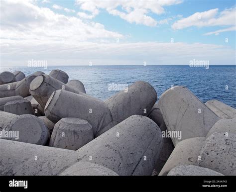Concrete Interlocking Tetrapods Used To Prevent Coastal Erosion Placed On A Shoreline With A