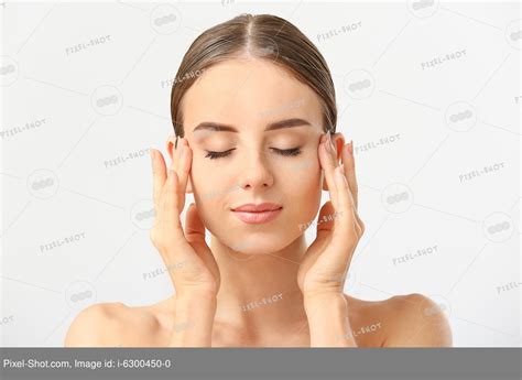 Beautiful Woman Massaging Her Face Against White Background Stock