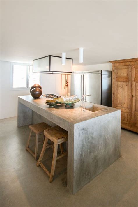 A concrete kitchen island would look awesome in a black and white setting like this one. 25 Industrial Kitchen Islands To Make A Statement - DigsDigs