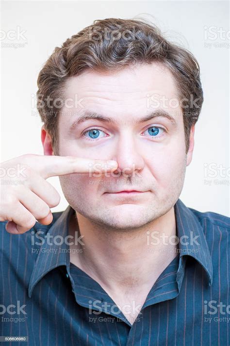 Portrait Of Man Points On His Nose Human Face Parts Stock Photo
