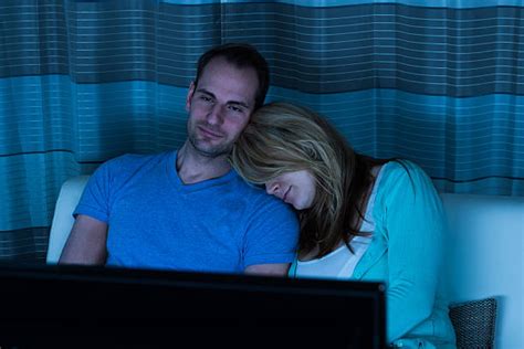 Woman Watching Tv While Her Husband Sleep Banco De Fotos E Imágenes