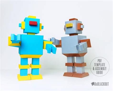 Two Paper Toy Robots Standing Next To Each Other