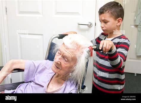 Young Boy Visiting His Very Old Great Grandmother In Care Home Stock