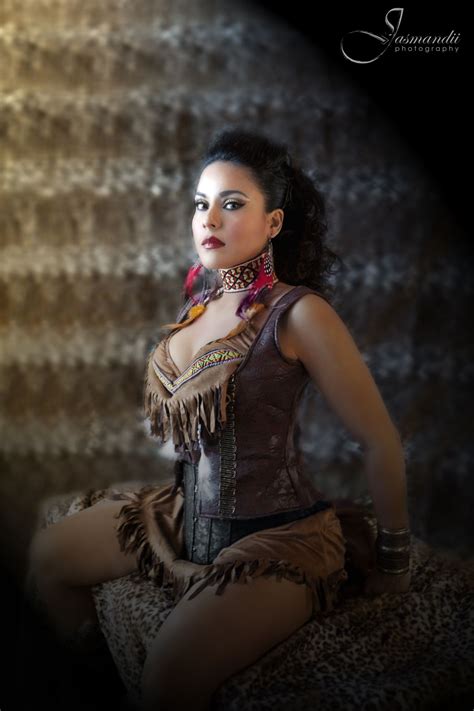 A Woman In A Corset Sitting On A Rock