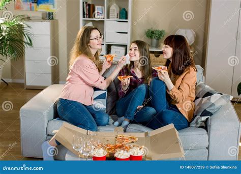 Portrait Of Three Happy Young Female Friends In Casual Clothes Eating