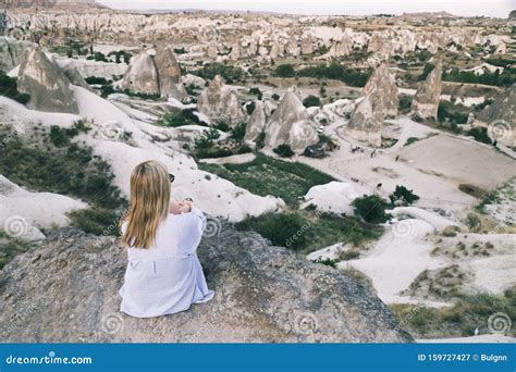 Girl Sitting On The Top Of Mountain In Cappadocia Turkey Aerial View