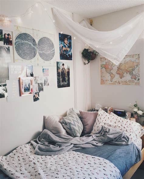 An Unmade Bed In A Bedroom With Pictures On The Wall And Lights Above It