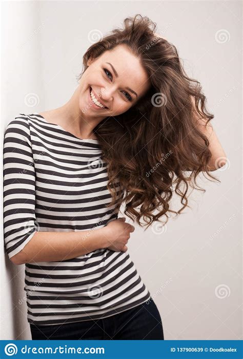 Happy Brunette Woman With Curly Hair And Perfect Smile Posing Stock
