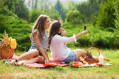 Two Young Girls Having Fun On The Picnic Making Selfie On A Smartphone Stock Image Image Of