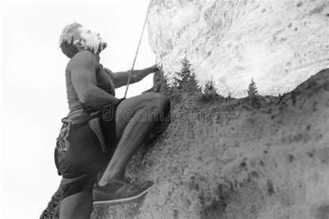 Young Man Climbing A Steep Wall In Mountain Stock Photo Image Of