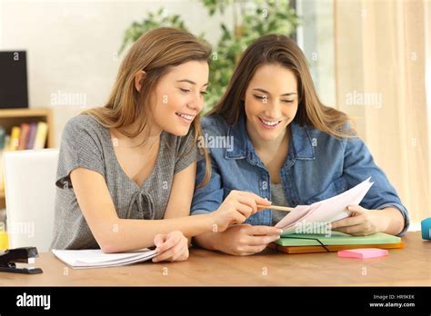 Two Students Doing Homework Together And Helping Each Other Sitting In