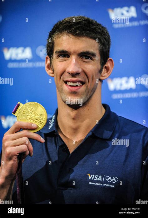 us swimmer michael phelps shows one of his gold medals at a press conference during the london