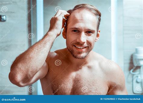 Hombre Desnudo Hermoso Que Comprueba Su Aspecto En Un Espejo Imagen De