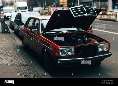 Old Fashioned Red Vintage Car With Opened Hood Parked On Street Of Town