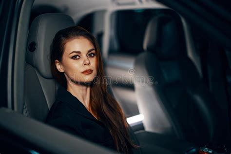 A Stylish Luxurious Woman Is Sitting In A Black Car At Night In The