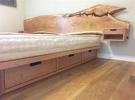 A Wooden Bed With Drawers Underneath It On The Floor In A Room That Has