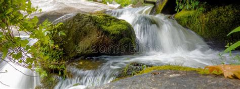 River Stream Flowing Over Rock Formations In The Mountains Stock Photo