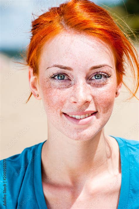 Portrait Of A Happy Smiling Beautiful Young Redhead Woman With Blue