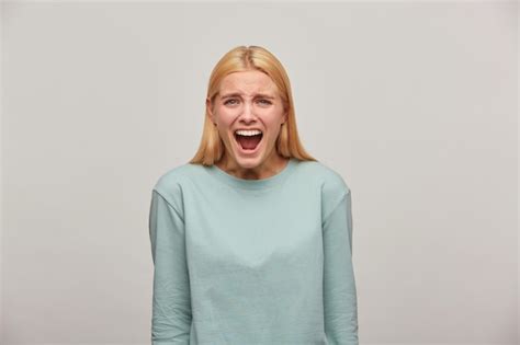 Free Photo Scared Blonde Woman Looks Frightened Afraid Imitate Scream Shout Utter A Loud Call