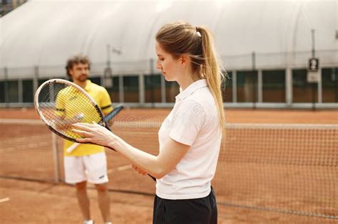 Male Tennis Player Standing In Court And Woman Standing In Front Stock