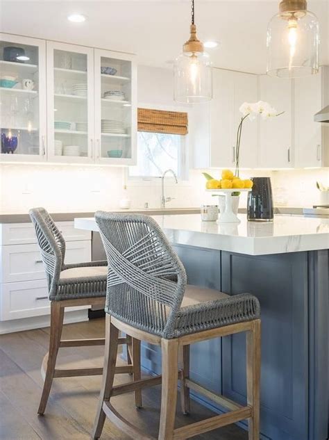 Make sure this room's centerpiece has comfortable seating for your guests. Gray kitchen island features gray woven counter stools ...