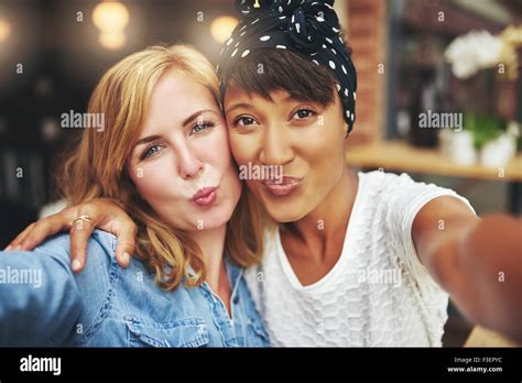 Zwei Attraktive Verspielte Junge Frauen Stehen Arm In Arm Weht Einen Kuss In Die Kamera Ihre