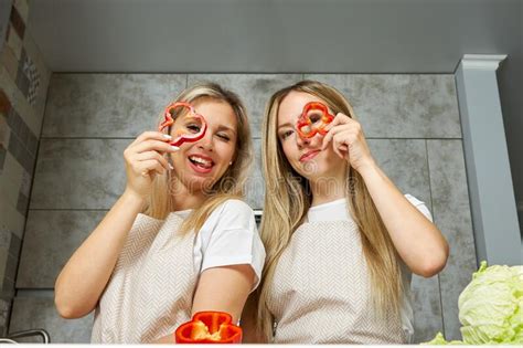 Two Cute Blonde Women Have Fun While Cooking In The Kitchen Stock Image