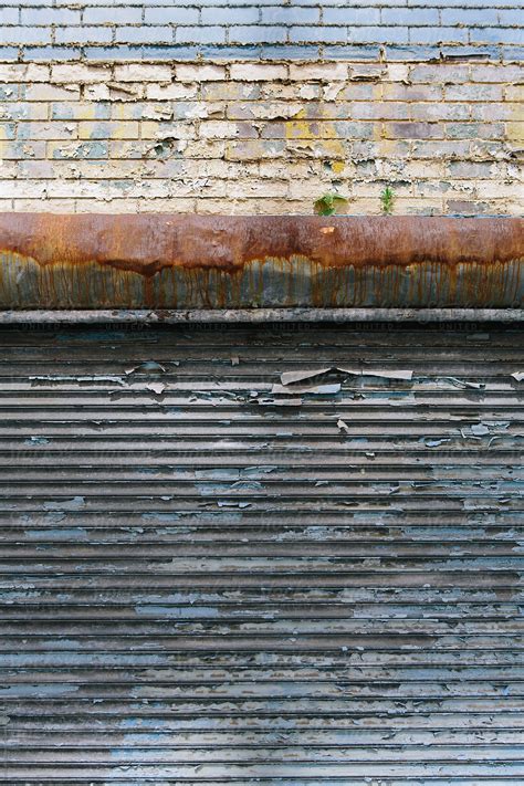 Detail Of Building Exterior And Peeling Paint On Old Garage Door Del