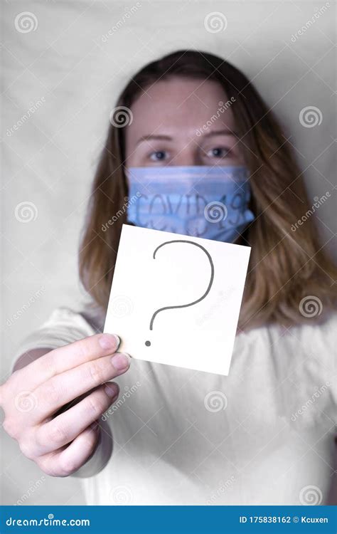 Question Mark On Sticker Held By Young Woman Wearing Medical Mask Stock