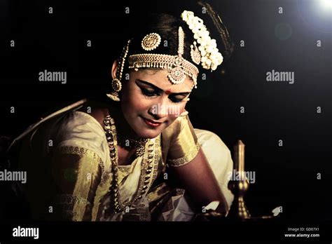 A Beautiful Indian Traditional Dance Mohiniyattam Dancer With A Pose Near A Golden Lamp In A