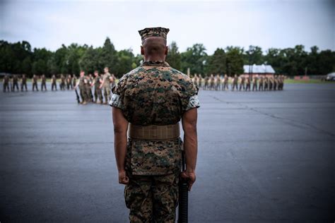 Marines standing in formation of officer wearing cammies.