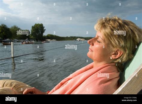 Woman Relaxing In Lawn Chair By River Stock Photo Alamy