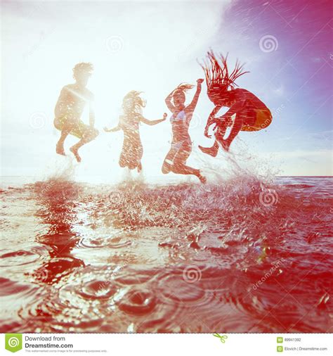 Summer Silhouettes Of Happy Young People Jumping In Sea On The B Stock