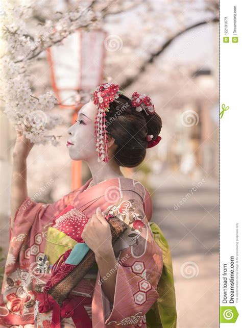 Cute Japanese Geisha Maiko Girl In Kimono Posing In Profile Admiring Cherry Blossoms At Su Stock