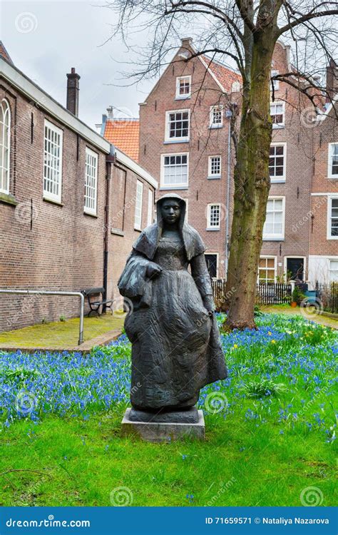 Begijnhof Courtyard With Statue And Historic Houses In Amsterdam